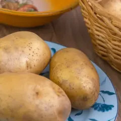Ziemniaki na talerzu i w koszyku. Zastanawiasz się, co sadzić po ziemniakach? Wybierz rośliny strączkowe lub kapustne.