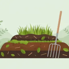 Warstwowy kompost z trawy, liści i patyków, obok widły ogrodnicze.